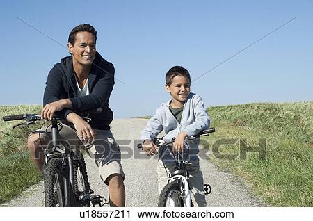 Stock Image - Father and son with their bikes. Fotosearch