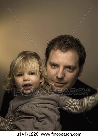 Father holding smiling daughter View Large Photo Image Stock Photograph - Father holding smiling daughter. Fotosearch