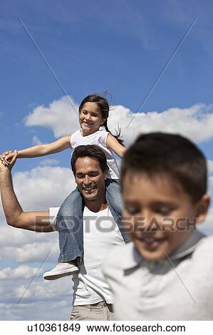 Stock Photo - Father with children running in a field. Fotosearch