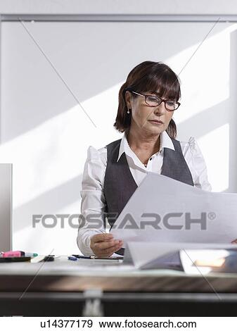 Stock Photo - Female Architect reviewing plans. Fotosearch