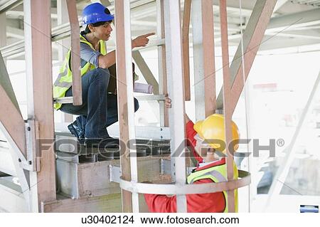 Female architect talking to a builder View Large Photo Image Picture - Female architect talking to a builder. Fotosearch