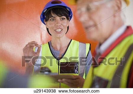 Female architect talking to builders View Large Photo Image Stock Photo - Female architect talking to builders. Fotosearch
