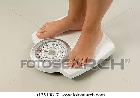 Stock Photo - Female feet on scales. Fotosearch