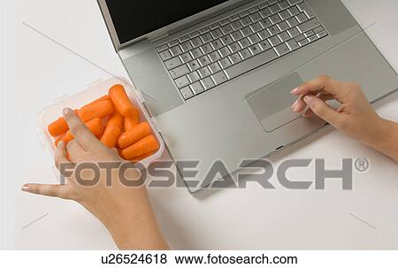 Female healthy eating at work View Large Photo Image Stock Photo - Female healthy eating at work. Fotosearch