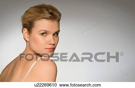 Stock Image - Female looking over shoulder at camera. Fotosearch