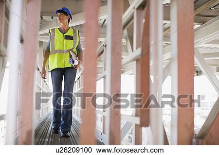 Stock Image - Female worker on construction site. Fotosearch