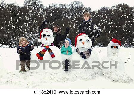 Stock Photo - Four boys and three snowmen. Fotosearch