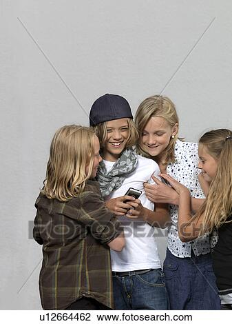 Four kids with mobile phone View Large Photo Image Stock Image - Four kids with mobile phone. Fotosearch