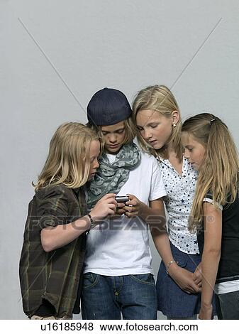Stock Photo - Four kids with mobile phone. Fotosearch