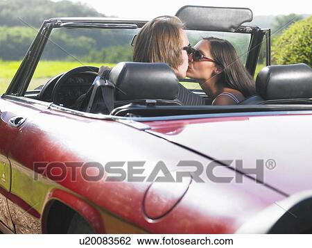 Stock Image - Freshly married couple kissing in car. Fotosearch
