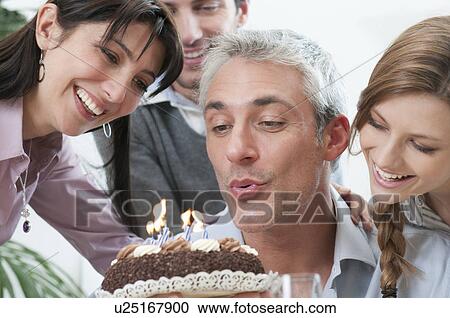 Friends blowing on birthday candles cake View Large Photo Image Stock Image - Friends blowing on birthday candles cake. Fotosearch