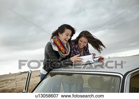 Friends looking in map View Large Photo Image Stock Photo - Friends looking in map. Fotosearch
