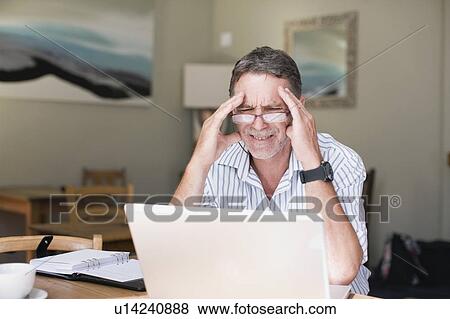 Stock Photo - Frustrated businessman using laptop. Fotosearch