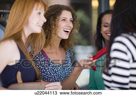Stock Image - Girfriends on shopping tour having fun. Fotosearch