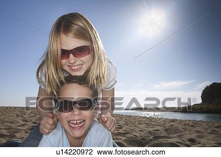 Girl and boy with sunglasses at beach View Large Photo Image Stock Image - Girl and boy with sunglasses at beach. Fotosearch