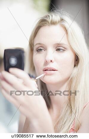 Girl doing her makeup View Large Photo Image Stock Photo - Girl doing her makeup. Fotosearch
