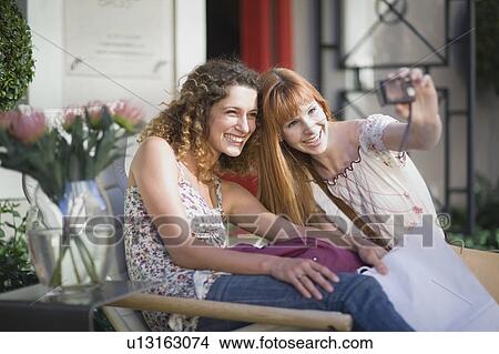 Picture - Girl friends taking pictures. Fotosearch
