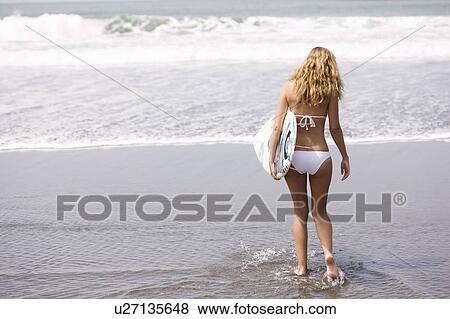 Girl in bikini with surfboard in water View Large Photo Image Stock Photo - Girl in bikini with surfboard in water. Fotosearch