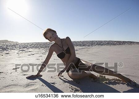 Stock Photograph - Girl laying on beach. Fotosearch