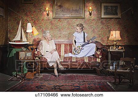 Stock Photograph - Girl playing guitar for grandmother. Fotosearch