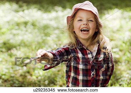 Stock Photography - Girl playing with stick outdoors. Fotosearch