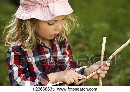 Girl playing with sticks outdoors View Large Photo Image Stock Photography - Girl playing with sticks outdoors. Fotosearch