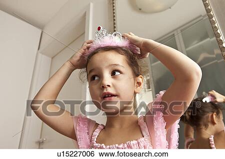 Girl putting crown on her head View Large Photo Image Stock Photograph - Girl putting crown on her head. Fotosearch
