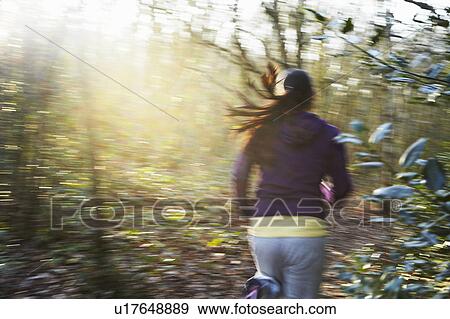 Girl running through forest in the sun View Large Photo Image Stock Photo - Girl running through forest in the sun. Fotosearch