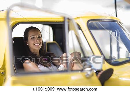 Girl sitting in yellow fun car View Large Photo Image Stock Photo - Girl sitting in yellow fun car. Fotosearch