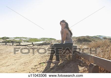 Girl sitting on a fence View Large Photo Image Stock Photograph - Girl sitting on a fence. Fotosearch