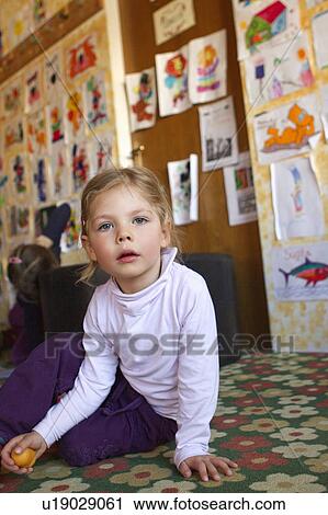 Girl sitting on floor in daycare View Large Photo Image Stock Image - Girl sitting on floor in daycare. Fotosearch
