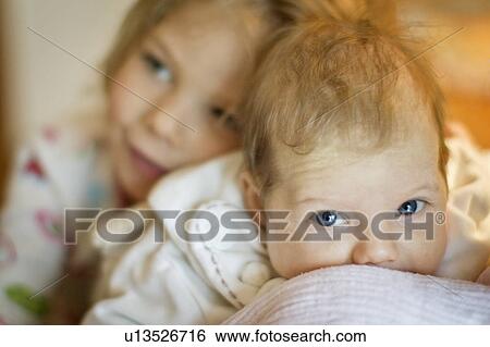 Girl smiling with baby sister View Large Photo Image Stock Photograph - Girl smiling with baby sister. Fotosearch