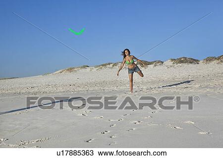 Stock Image - Girl throwing boomerang. Fotosearch