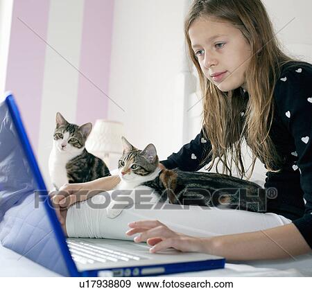 Stock Photo - Girl using laptop with kittens. Fotosearch