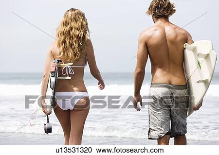 Girl walking with surfboard in water View Large Photo Image Stock Image - Girl walking with surfboard in water. Fotosearch