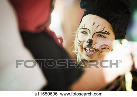 Stock Photograph - Girl wearing face paint at carnival. Fotosearch