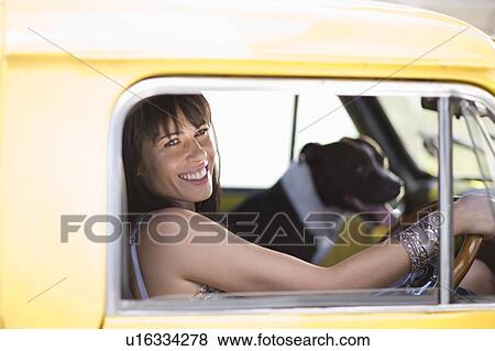Girl with dog sitting in yellow fun car View Large Photo Image Stock Photo - Girl with dog sitting in yellow fun car. Fotosearch