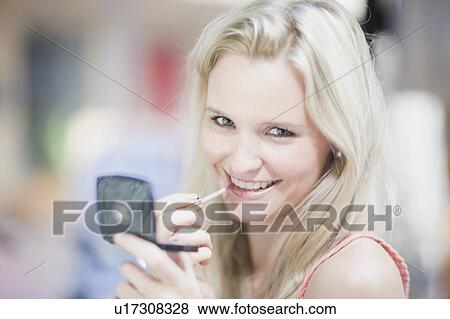 Stock Photo - Girl with lipgloss and mirror. Fotosearch