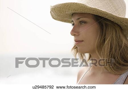 Girl with straw hat in profile View Large Photo Image Stock Image - Girl with straw hat in profile. Fotosearch