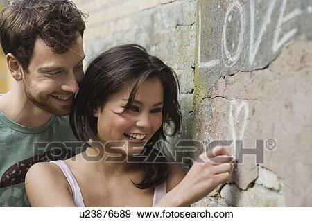Girlfriend writing LOVE on a wall View Large Photo Image Stock Photo - Girlfriend writing LOVE on a wall. Fotosearch