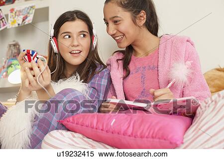 Stock Photography - girlfriends checking messages on phone at home . Fotosearch
