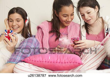 girlfriends hanging out in bed at home View Large Photo Image Stock Photo - girlfriends hanging out in bed at home . Fotosearch