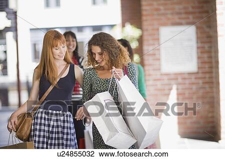 Girlfriends on shopping tour looking in bags View Large Photo Image Stock Image - Girlfriends on shopping tour looking in bags. Fotosearch