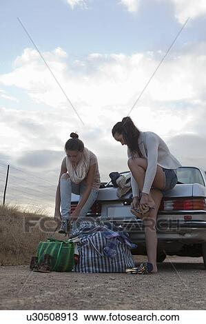 Stock Image - Girls changing shoes. Fotosearch