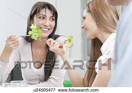 Girls eating fresh salad for lunch View Large Photo Image Stock Photo - Girls eating fresh salad for lunch. Fotosearch