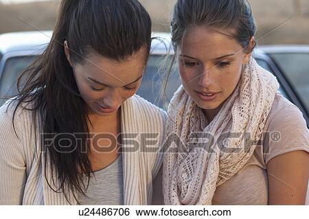 Stock Photograph - Girls looking on ground. Fotosearch