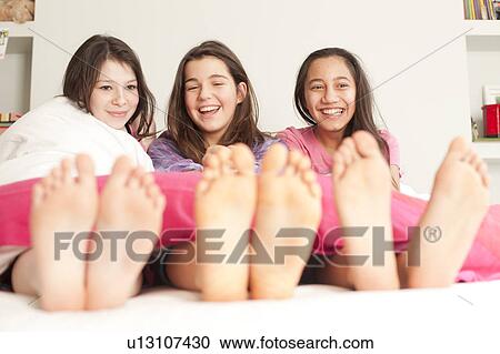 girls lying in bed laughing View Large Photo Image Stock Image - girls lying in bed laughing. Fotosearch