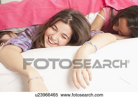 girls lying in bed laughing View Large Photo Image Stock Photography - girls lying in bed laughing. Fotosearch