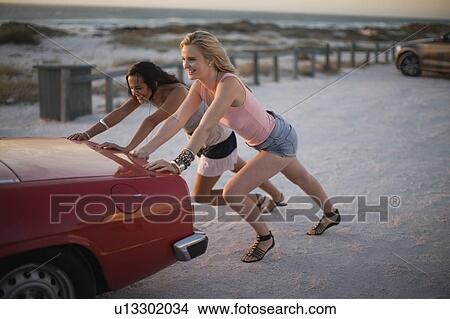 Girls pushing their broken car View Large Photo Image Picture - Girls pushing their broken car. Fotosearch