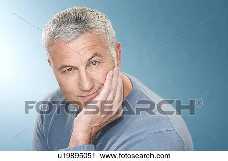 Stock Image - Grey hair man with head rest in hand. Fotosearch